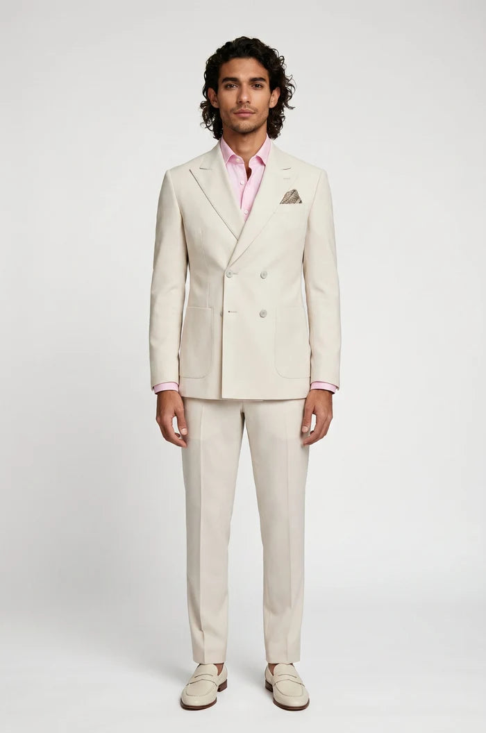 Man wearing a light beige suit with a pink shirt on a white background
