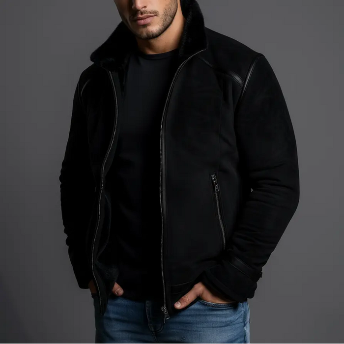 Man wearing a black jacket and jeans against a gray background