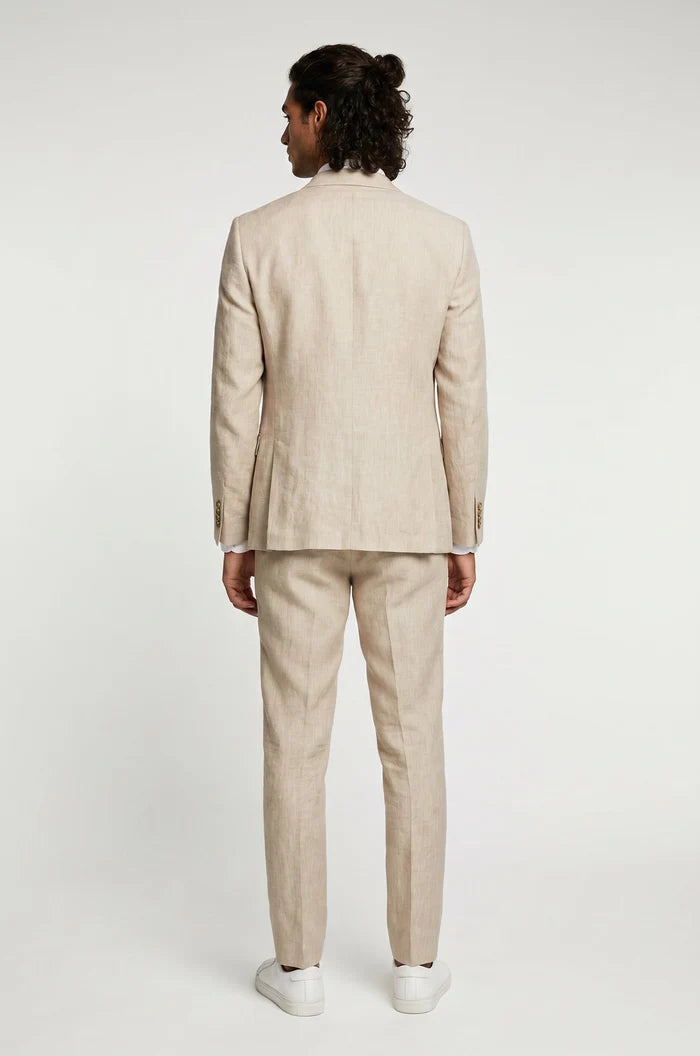 Man wearing a beige suit standing against a white background