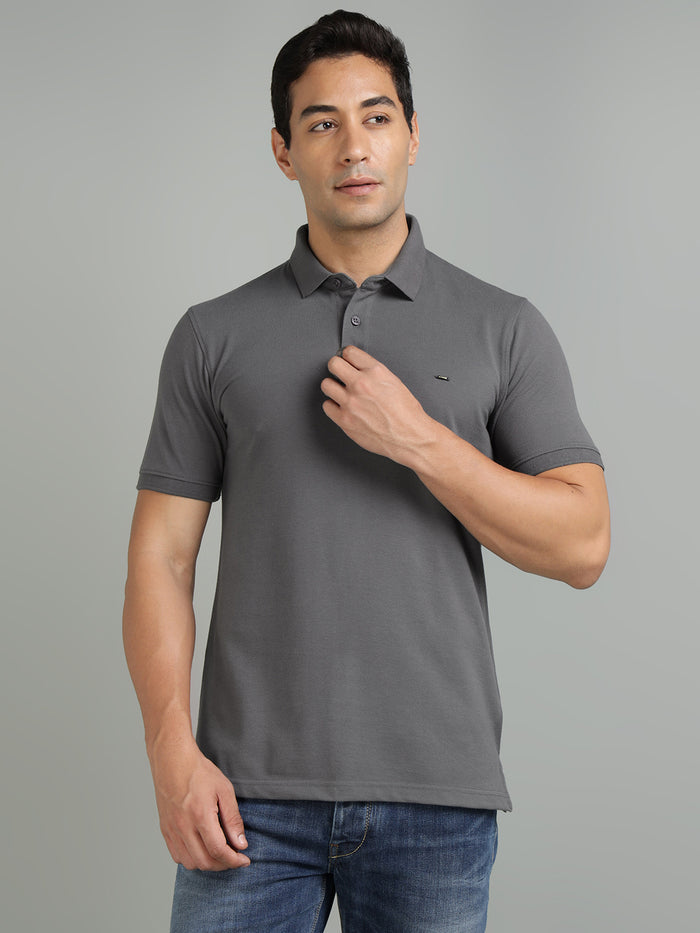 Man wearing a gray polo shirt against a gray background