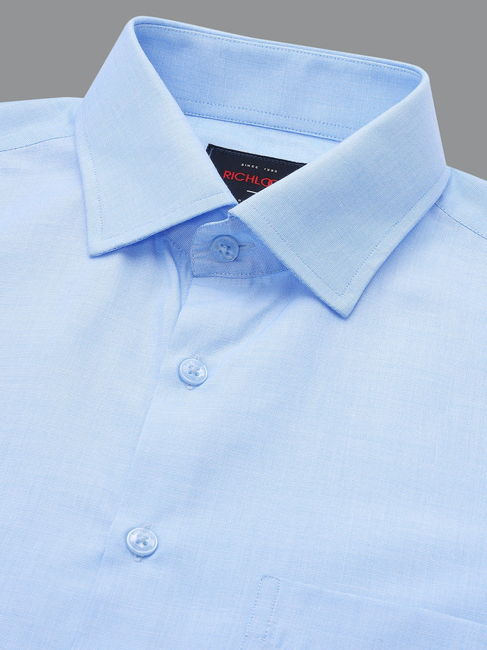 Close-up of a light blue dress shirt with collar and buttons on a gray background