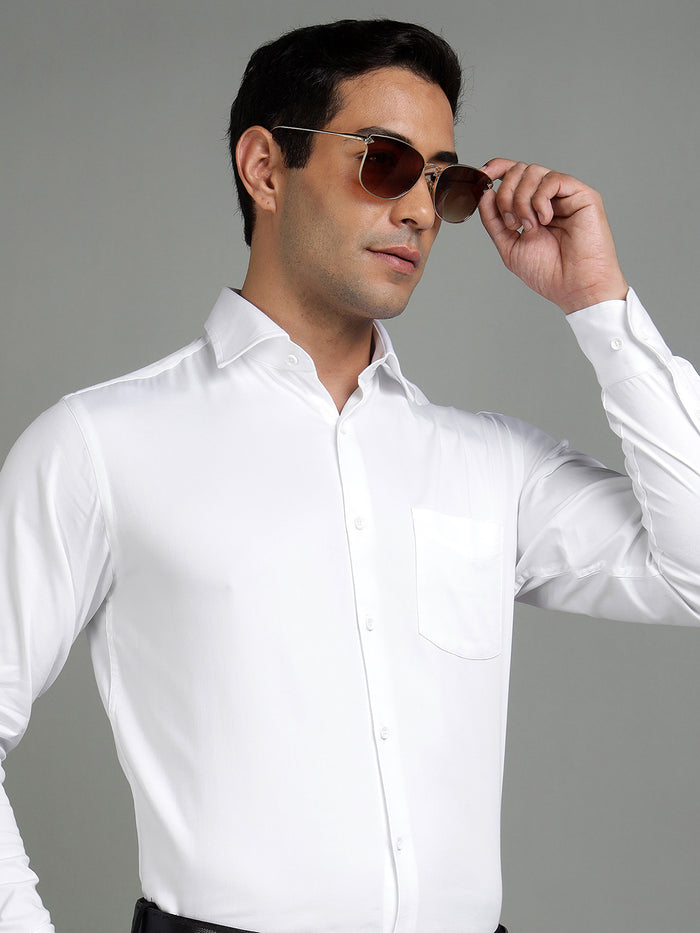 Man wearing a white dress shirt and sunglasses against a gray background