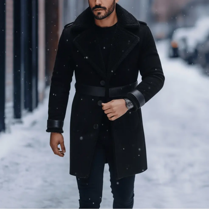 Man wearing a black coat standing on a snowy street