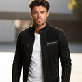 Man wearing a black jacket over a white shirt with a blurred background