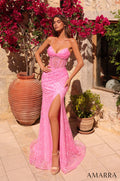 A woman wears a form-fitting Barbie Pink sequin gown with a high slit, standing amid terracotta pots and vibrant flowers.