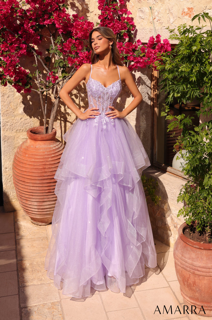 A woman wears a flowing lilac tulle ball gown with a corset top, standing amid vibrant pink bougainvillea flowers.