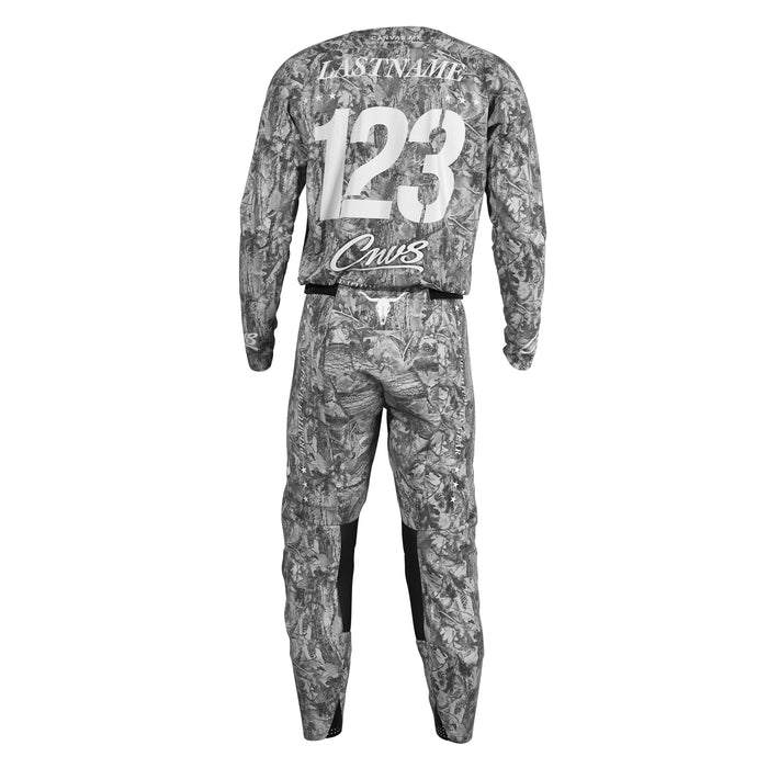 Gray and black camouflage motocross jersey and matching pants set shown from the back, featuring customizable text placeholders 'LASTNAME', '123', and 'Cnvs'.