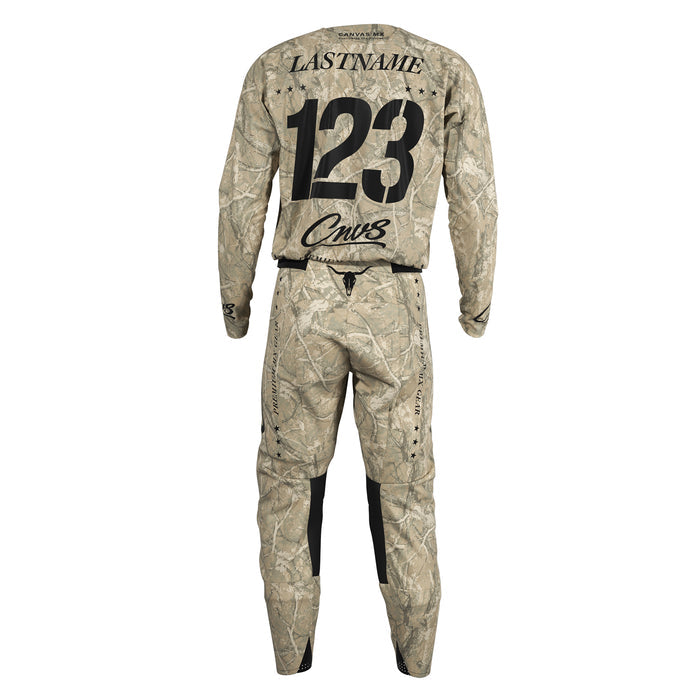 Custom long-sleeve motocross jersey and matching pants in a beige and brown woodland camouflage pattern, shown from the back with customizable text fields 'LASTNAME', '123', and 'Cnvs'.
